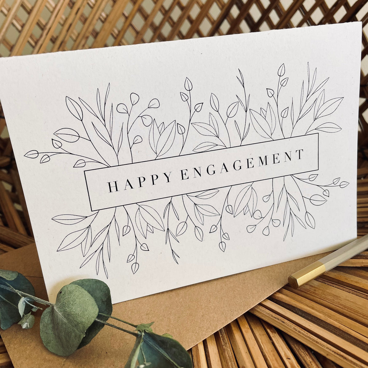 happy engagement card in black foil text on recycled card with a brown envelope