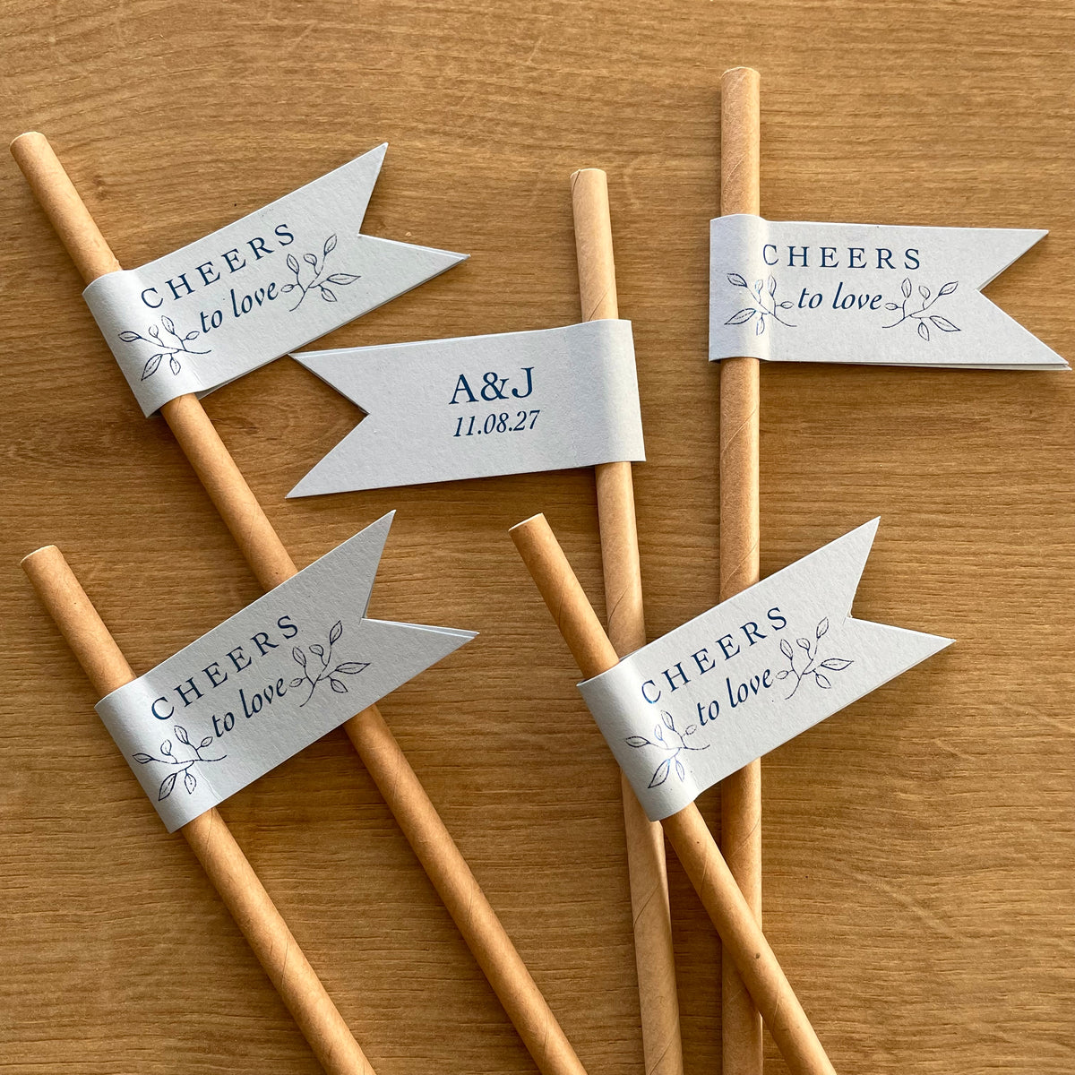 cheers to love brown paper straws with light blue card and blue foil personalised with couples initials and date for wedding day, engagement party or anniversary celebration