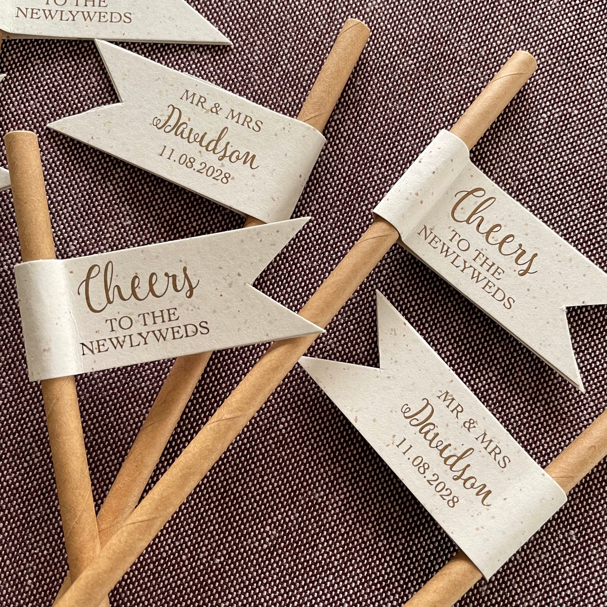 paper drink straw with recycled card and bronze foil with cheers to the newlyweds on the front of the flag, customisable on the back of the flag with married name, titles and wedding date