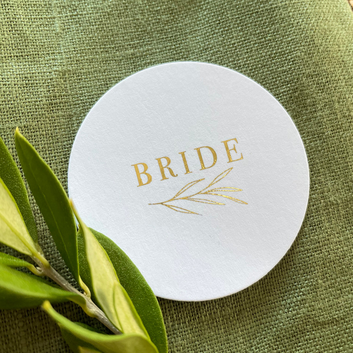 round white name tags with gold foil text for place settings