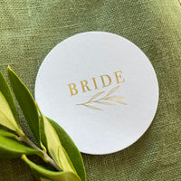 round white name tags with gold foil text for place settings