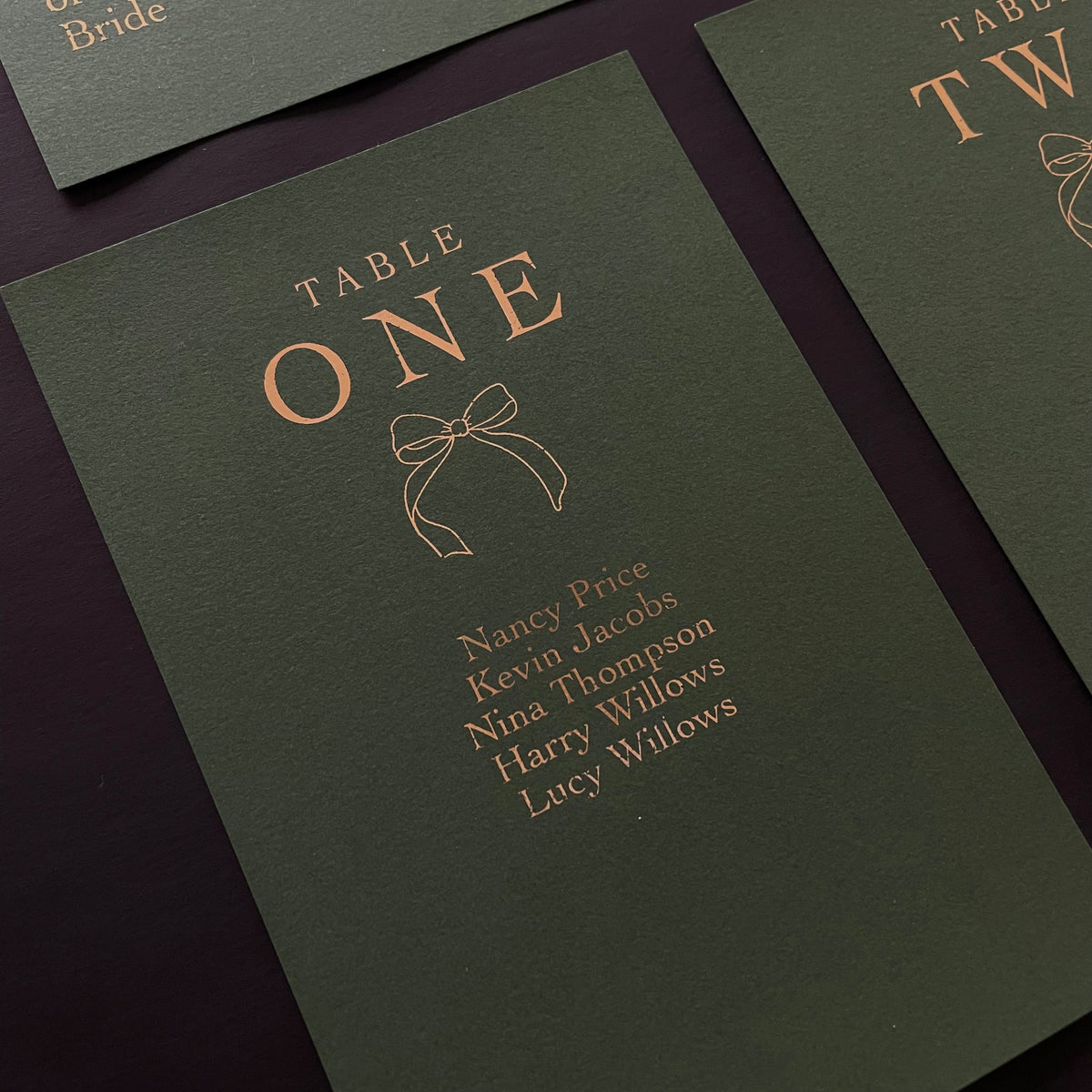 green and gold foil festive bow table plan cards for wedding reception