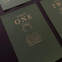 green and gold foil festive bow table plan cards for wedding reception