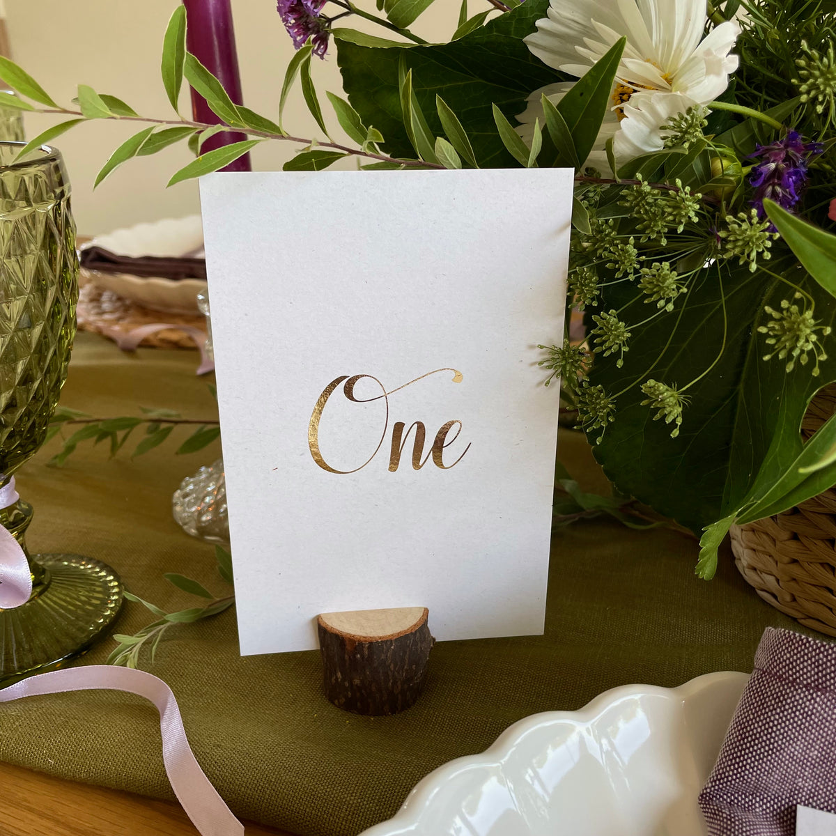 a recycled table number foiled in gold for elegant wedding tablescapes