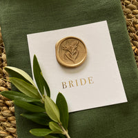 flat square name card with gold wax seal and gold foil guest name for place settings on table