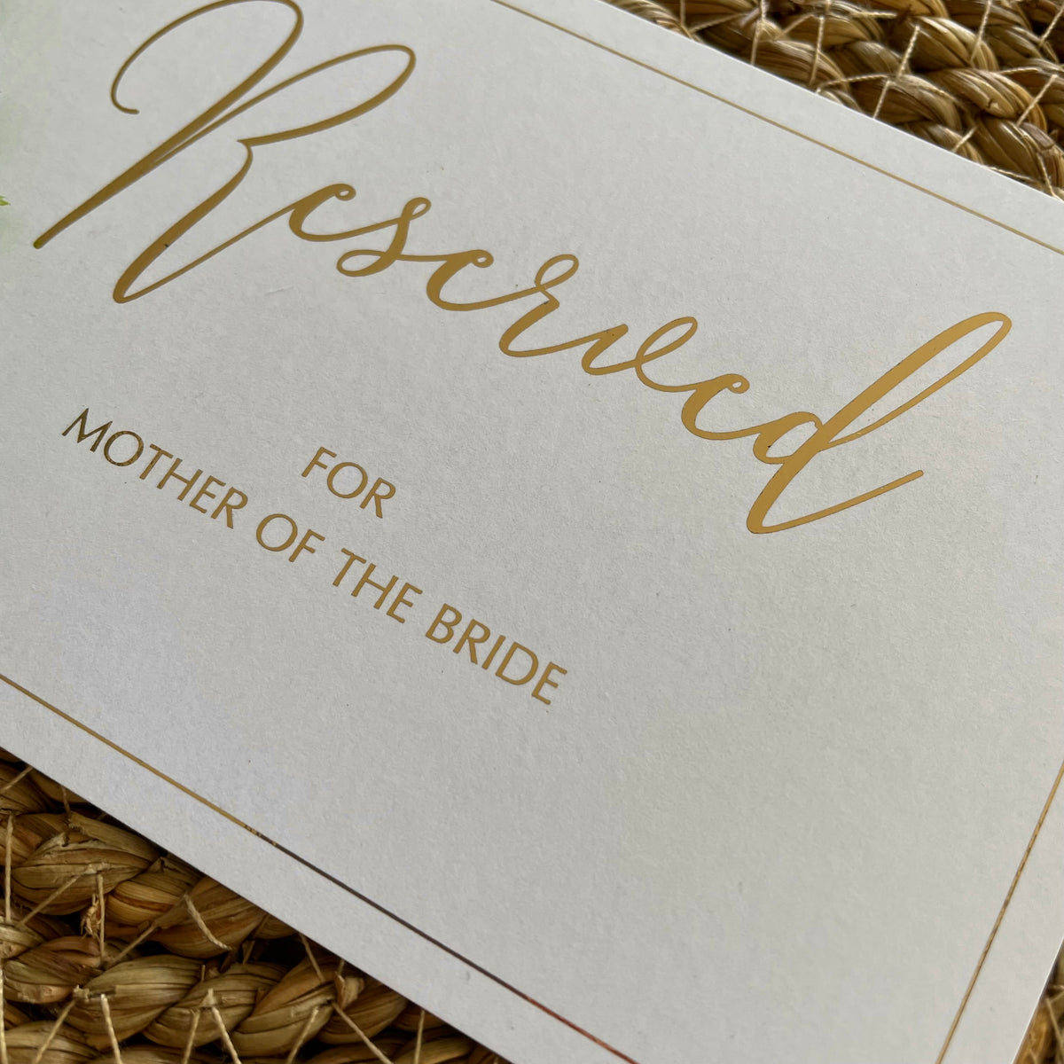 close up of gold foil on white rectangular seating cards for reserved guests