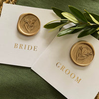 flat name cards for wedding on white card with gold foil and a gold wax seal