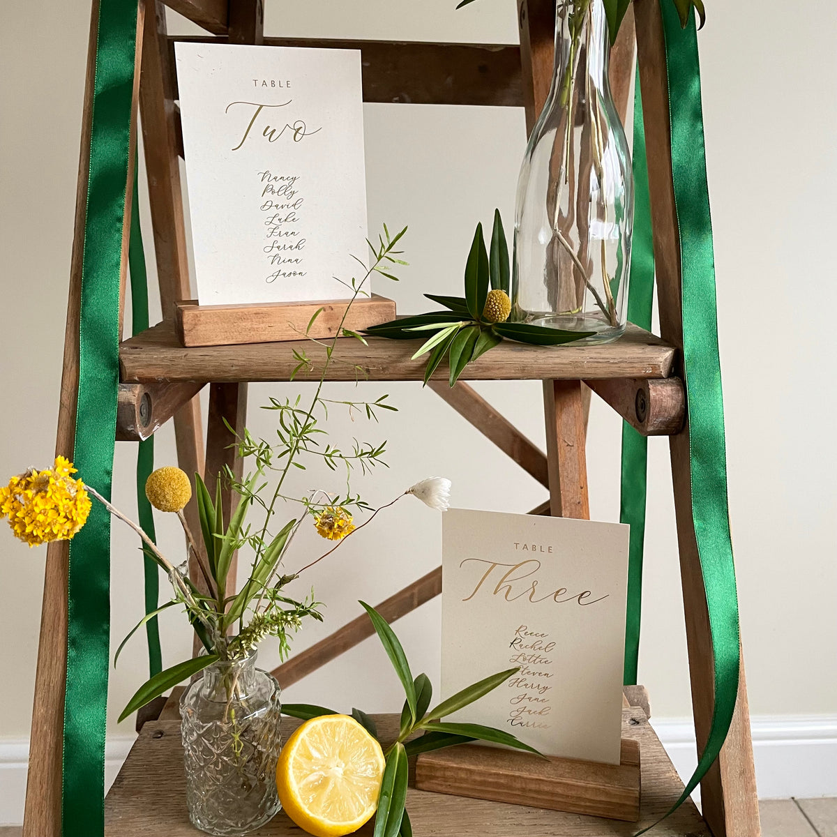 seating plan cards on wooden ladder