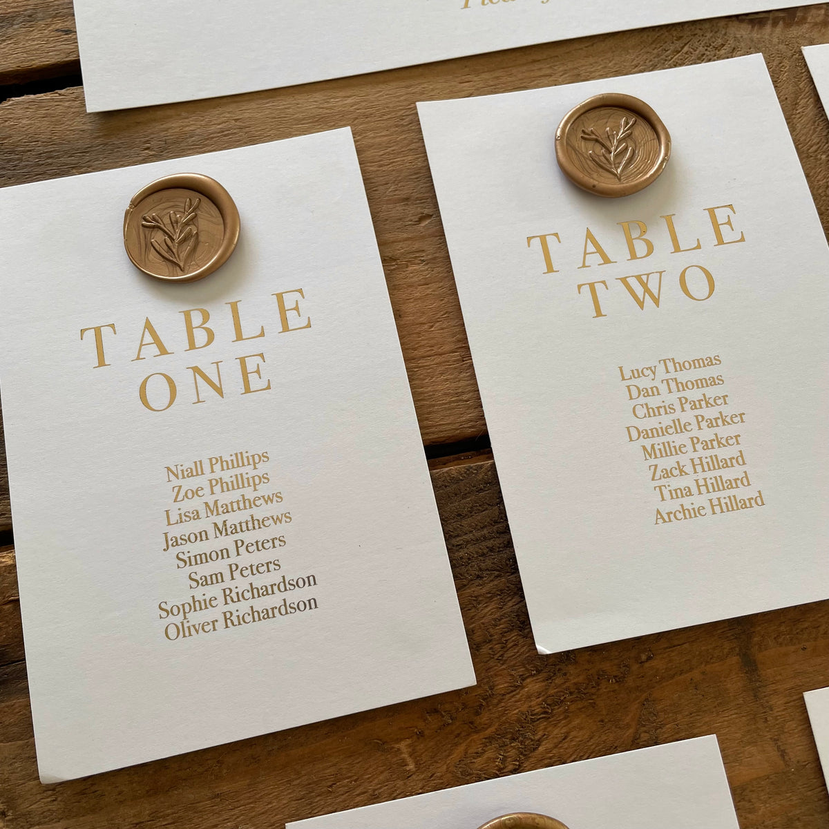 table seating cards with gold wax seal and gold foil guest names