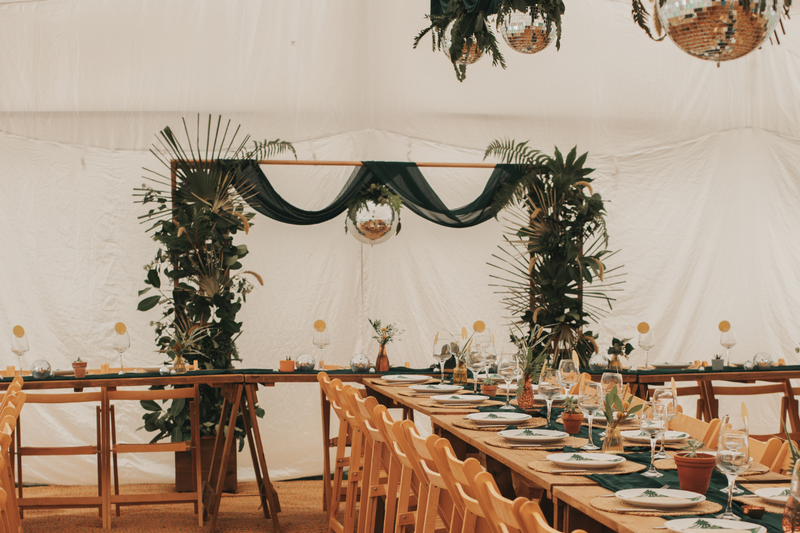 Disco ball and tropical greenery wedding backdrop