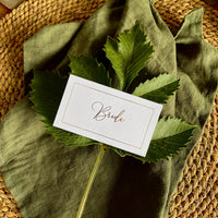 flat rectangular place setting cards on white card with swirly gold foil font for guests names
