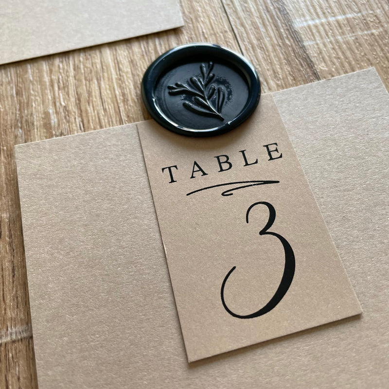 black wax seals with floral leaf for table plan